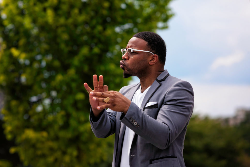 A man in a suit and glasses clapping