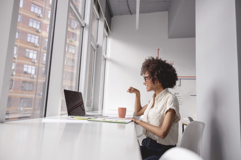 A woman sitting at a table with her laptop.